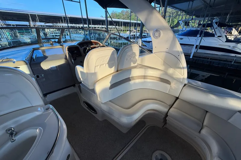Slide: The Image of 2003 Sea Ray 340 Sundancer cockpit with plush seating and helm, docked at marina. - 6