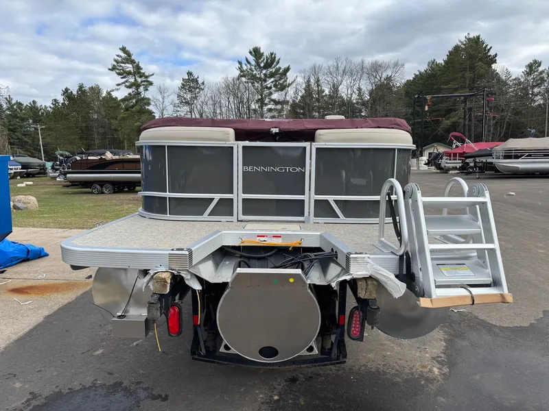 Slide: The Image of 2026 Bennington 22SSR-SPS pontoon boat with ladder, parked outdoors. - 7