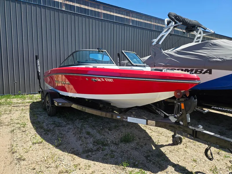 Slide: The Image of Red 2019 Nautique 200 boat on trailer beside warehouse. - 4