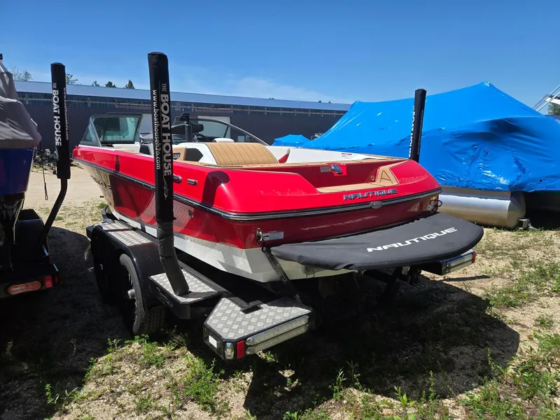 Slide: The Image of Red 2019 Nautique 200 boat parked on trailer outdoors. - 9
