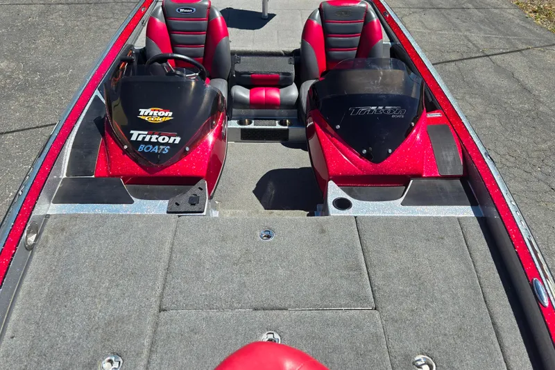 Slide: The Image of 2011 Triton 20XS DC boat interior with red and black seating, dual consoles. - 11
