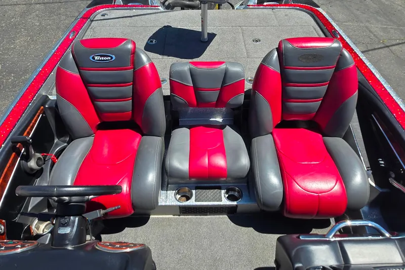 Slide: The Image of 2011 Triton 20XS DC boat interior with red and gray seating, steering wheel, and cup holders. - 18