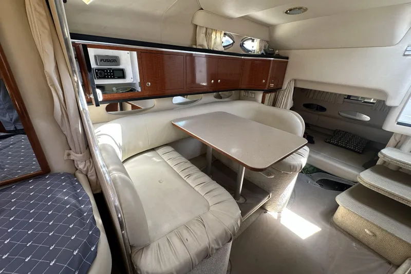 Slide: The Image of Interior of 2001 Sea Ray Sundancer 310 with dining area and wooden cabinetry. - 10