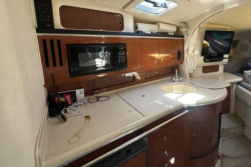 Slide: The Image of 2001 Sea Ray Sundancer 310 interior kitchen with microwave, sink, and TV. - 11