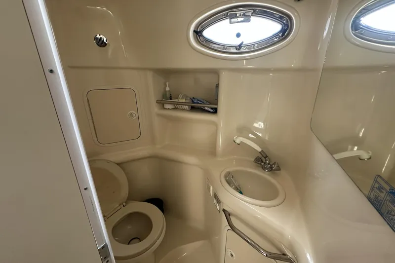 Slide: The Image of 2001 Sea Ray Sundancer 310 bathroom with toilet, sink, and oval window. - 12