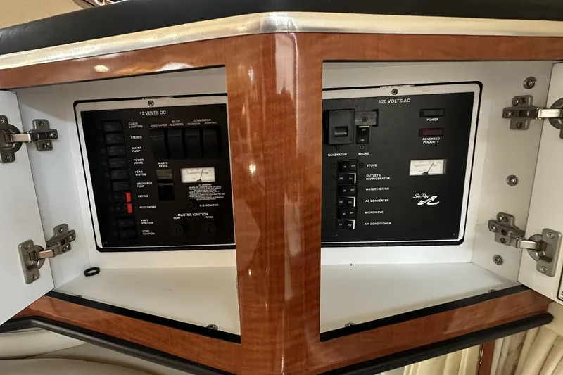Slide: The Image of Electrical control panel inside a 2001 Sea Ray Sundancer 310 boat, featuring AC and DC switches. - 13