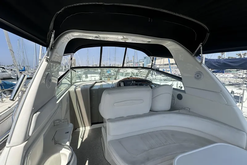 Slide: The Image of 2001 Sea Ray Sundancer 310 yacht interior with white seating, docked at marina. - 3