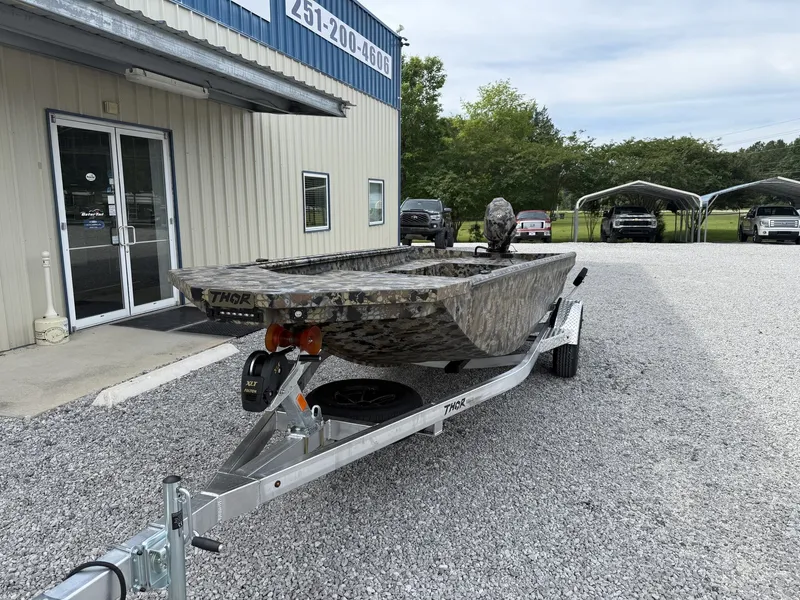 Slide: The Image of Thor Fish Hammer boat 2026 on trailer outside building. - 2