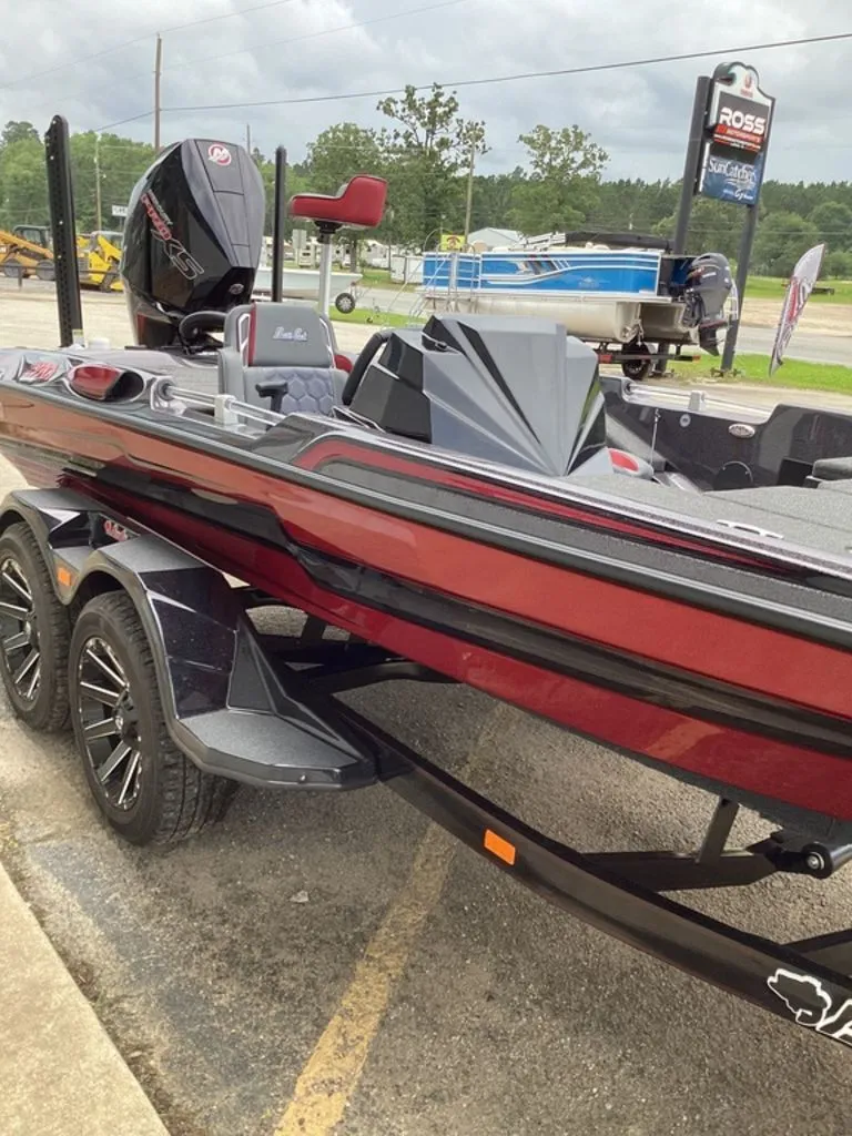 Slide: The Image of 2026 Bass Cat Eyra boat on trailer, red and black, parked outdoors. - 24