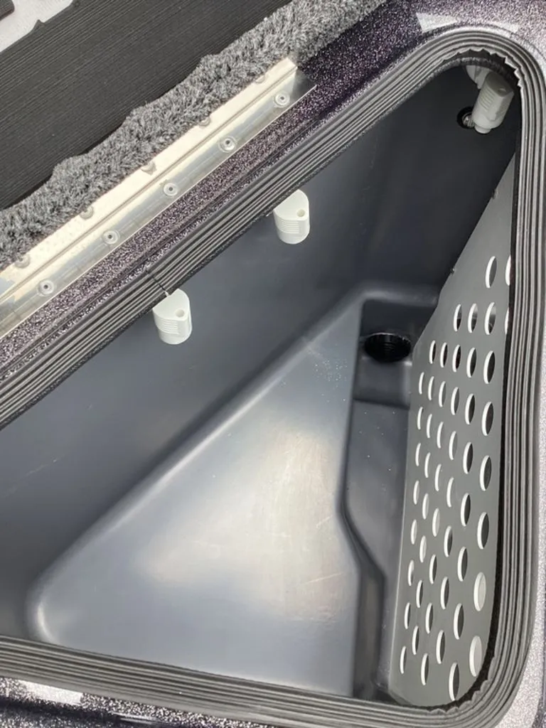 Slide: The Image of Interior of a 2026 Bass Cat Eyra boat, featuring storage compartment with ventilation holes. - 40