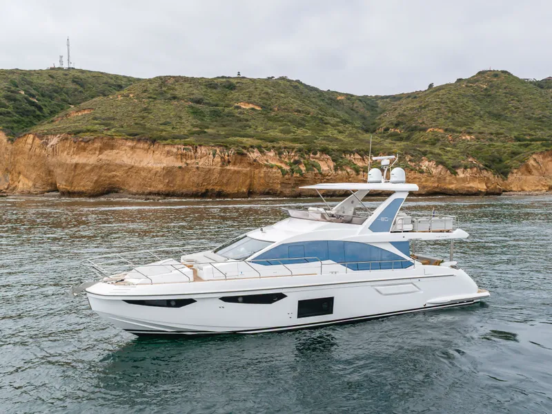 Slide: The Image of Azimut Fly 60 Yacht 2020 near rocky coastline. - 2