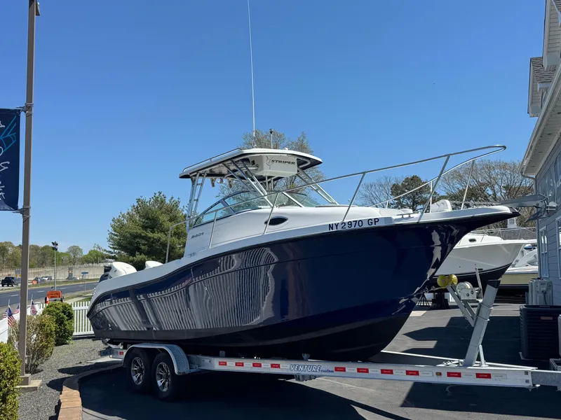 The Image of 2004 Seaswirl Striper 2601 boat on trailer outdoors. - 1