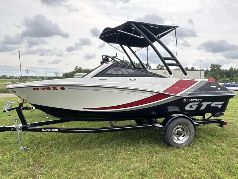 The Image of A 2019 Glastron GTS185 boat on a trailer, featuring a black and red design. - 1