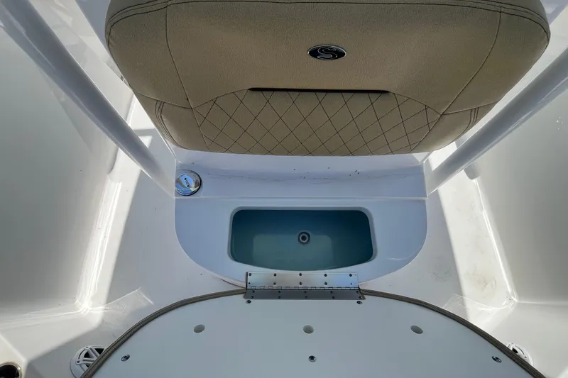 Slide: The Image of 2021 Sportsman Heritage 231 Center Console boat interior with cushioned seating and storage compartment. - 12