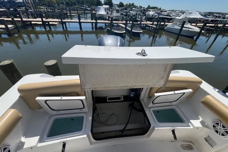 Slide: The Image of 2021 Sportsman Heritage 231 Center Console boat interior at marina, featuring storage compartments. - 5