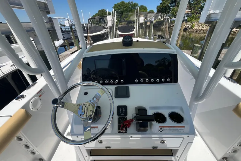 Slide: The Image of 2021 Sportsman Heritage 231 Center Console boat dashboard with steering wheel and controls. - 7