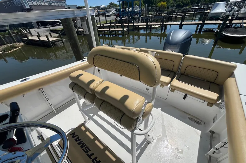 Slide: The Image of 2021 Sportsman Heritage 231 Center Console boat interior with tan seating and steering wheel. - 9
