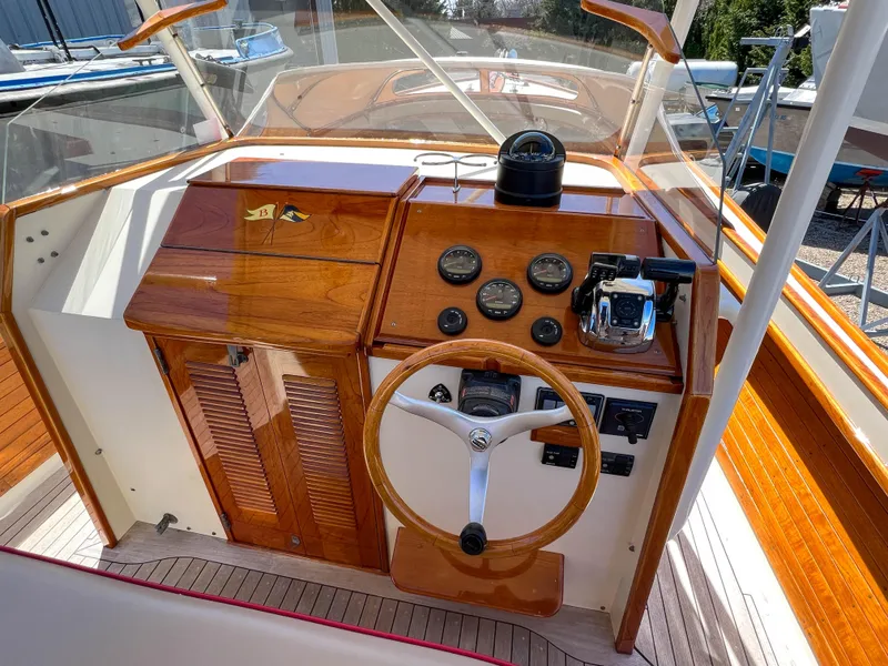 Slide: The Image of 2003 Padebco V27 Center Console helm with wooden dashboard and steering wheel. - 18