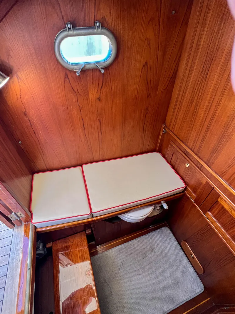Slide: The Image of 2003 Padebco V27 Center Console cabin interior with wooden finish and cushioned seating. - 25