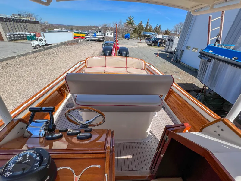 Slide: The Image of 2003 Padebco V27 Center Console boat with wooden interior and outdoor view. - 28