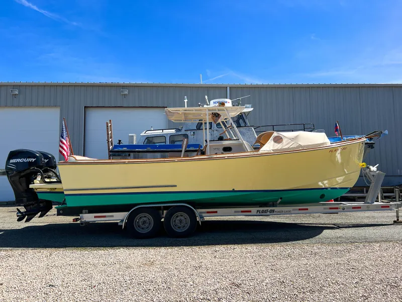 Slide: The Image of 2003 Padebco V27 Center Console boat on trailer, parked outside a warehouse. - 8