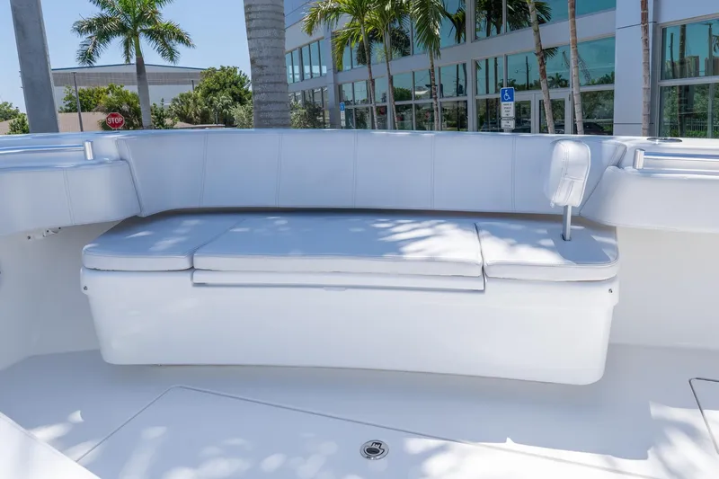 Slide: The Image of 2024 Contender 35 ST boat seating area with white cushions and palm trees in background. - 11