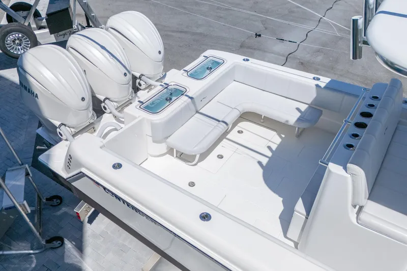 Slide: The Image of 2024 Contender 35 ST boat with triple Yamaha engines, spacious seating, and fishing rod holders. - 23