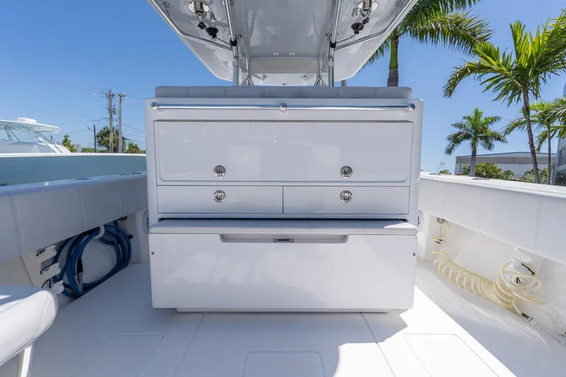 Slide: The Image of 2024 Contender 35 ST boat interior with storage drawers, sleek design, and palm trees in the background. - 25