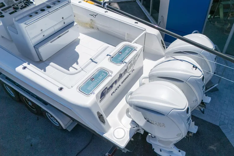 Slide: The Image of 2024 Contender 35 ST boat with triple outboard engines, spacious deck, and storage compartments. - 6