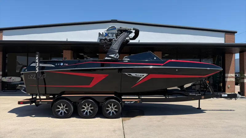 The Image of 2024 Tigé 24RZX boat with black and red design in front of a building. - 1