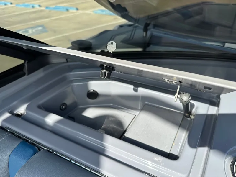 Slide: The Image of 2024 Malibu M242 boat, open storage compartment lid in sunlight. - 18