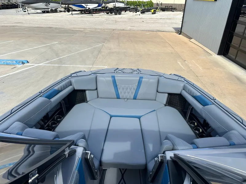 Slide: The Image of Interior of 2024 Malibu M242 boat with luxurious blue and gray seating. - 37