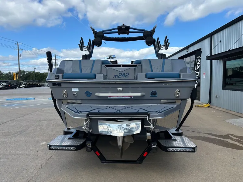 Slide: The Image of Rear view of 2024 Malibu M242 boat on a parking lot. - 4