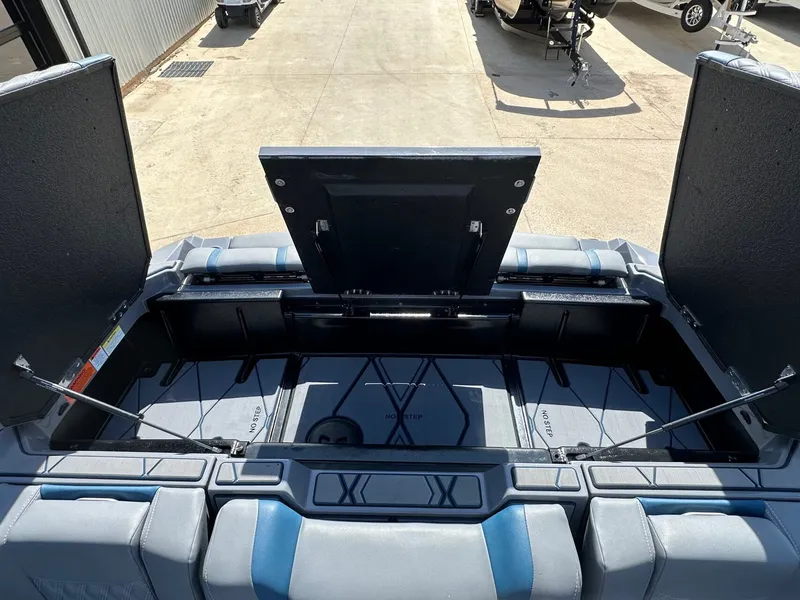 Slide: The Image of 2024 Malibu M242 boat with open storage compartment lid. - 49