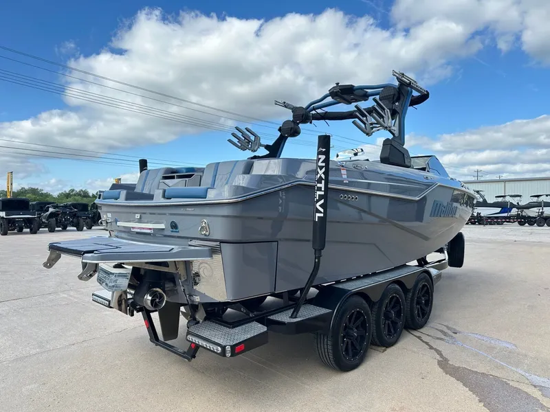 Slide: The Image of 2024 Malibu M242 boat on trailer, side view. - 5