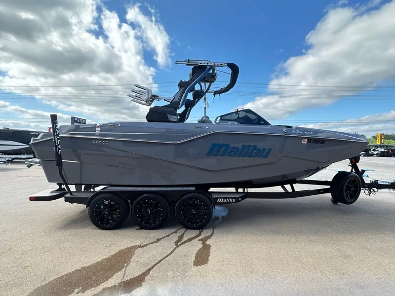 Slide: The Image of 2024 Malibu M242 boat on trailer under blue sky. - 6