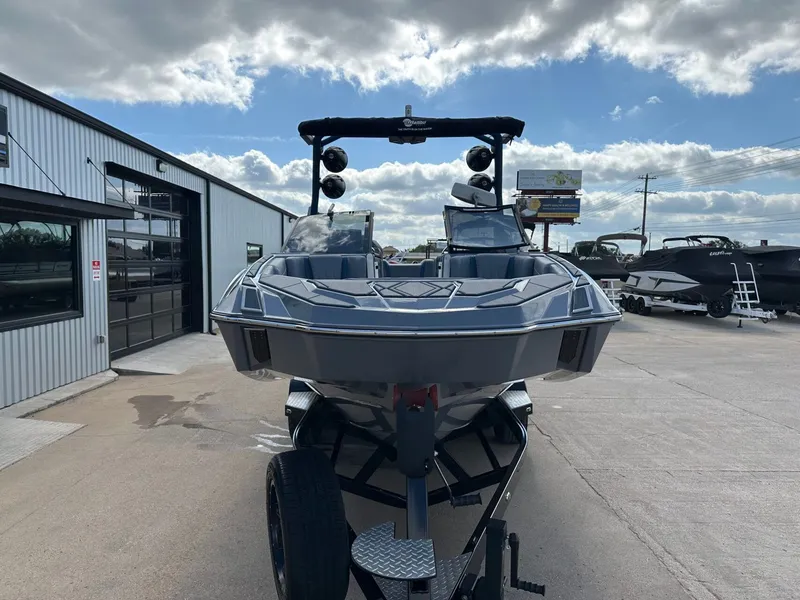 Slide: The Image of 2024 Malibu M242 boat on trailer in front of building. - 8