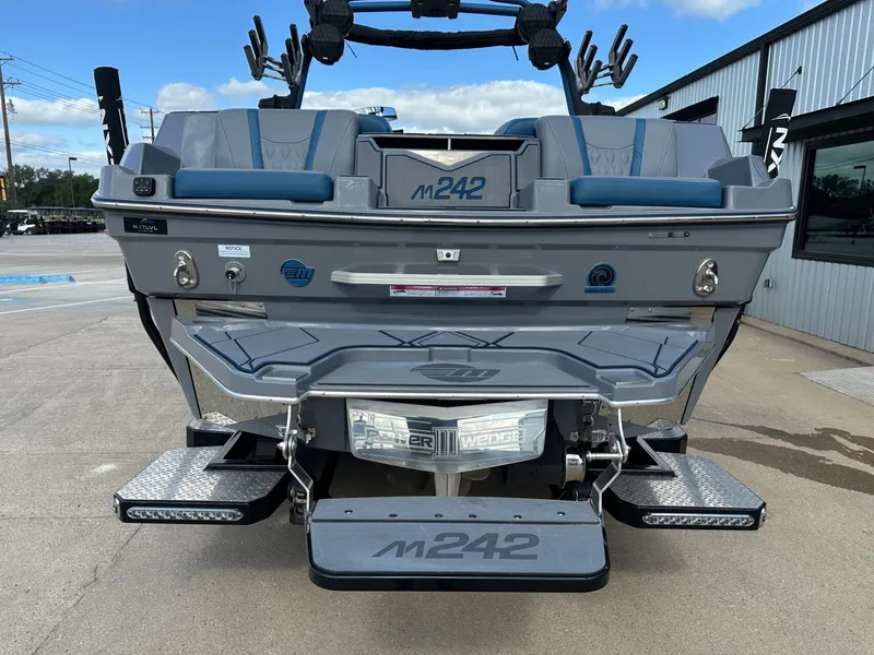 Slide: The Image of Rear view of 2024 Malibu M242 boat on a parking lot. - 9