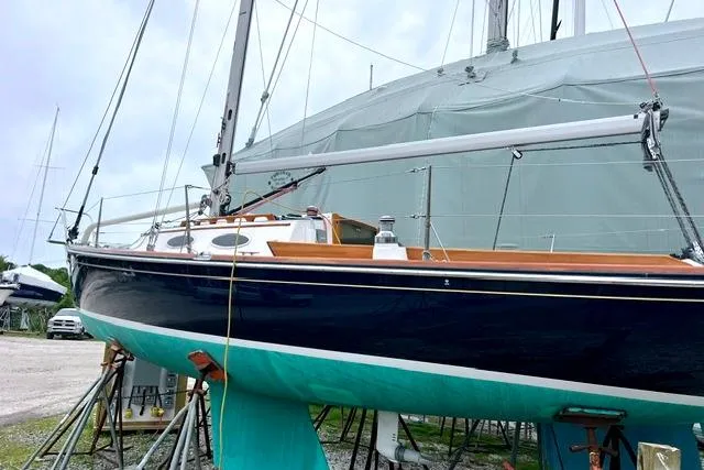 Slide: The Image of 2007 Alerion Express 28 sailboat on stands, with a sleek black hull and turquoise keel. - 3