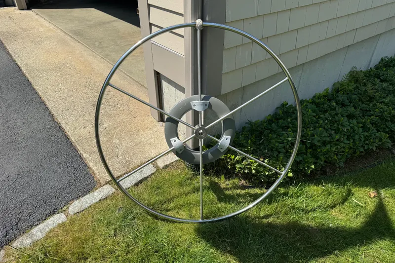 Slide: The Image of Stainless steel steering wheel from a 1996 Catalina 36 MkII sailboat, displayed outdoors. - 22