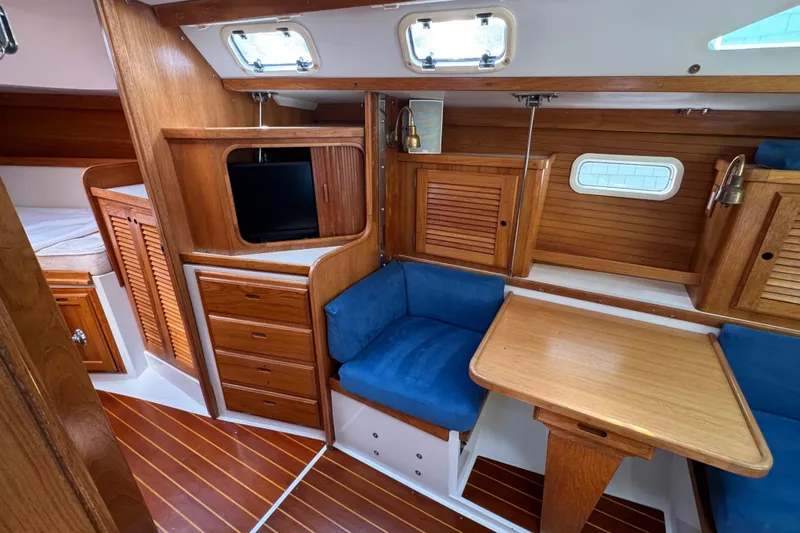 Slide: The Image of Interior of 1996 Catalina 36 MkII sailboat with wooden cabinetry and blue seating. - 33