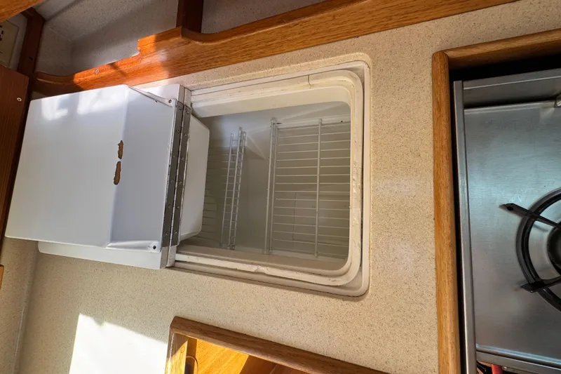 Slide: The Image of Interior view of a 1996 Catalina 36 MkII yacht kitchen with open fridge and stove. - 38