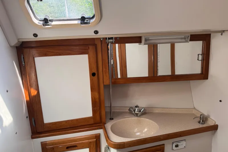 Slide: The Image of Interior of 1996 Catalina 36 MkII sailboat bathroom with wooden cabinets and sink. - 42