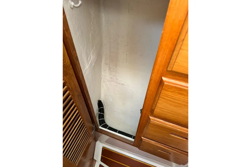 Slide: The Image of Interior view of a 1996 Catalina 36 MkII sailboat, featuring wooden cabinetry and storage space. - 45