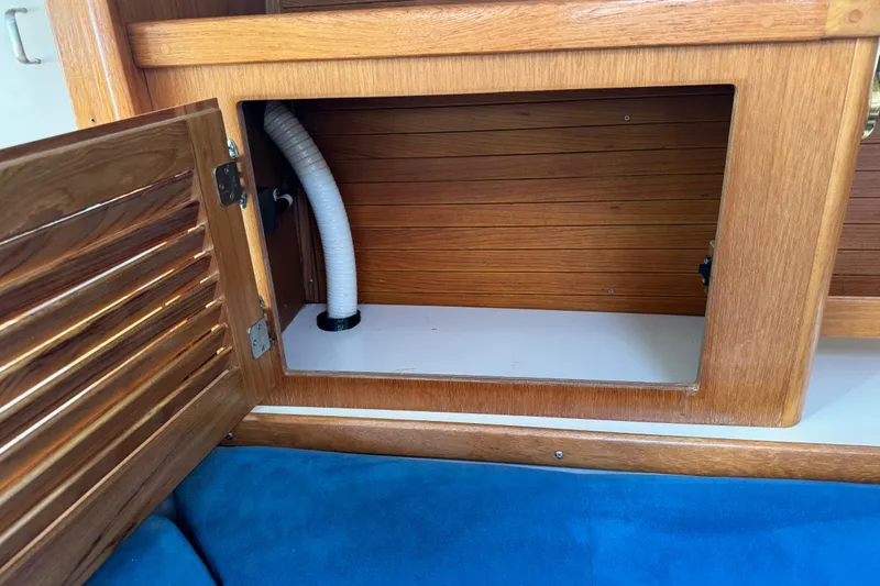 Slide: The Image of Open wooden cabinet on a 1996 Catalina 36 MkII sailboat, revealing interior storage space. - 47