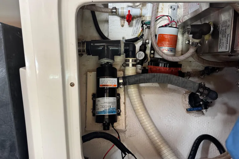 Slide: The Image of Engine compartment of a 1996 Catalina 36 MkII sailboat, showcasing plumbing and mechanical components. - 49