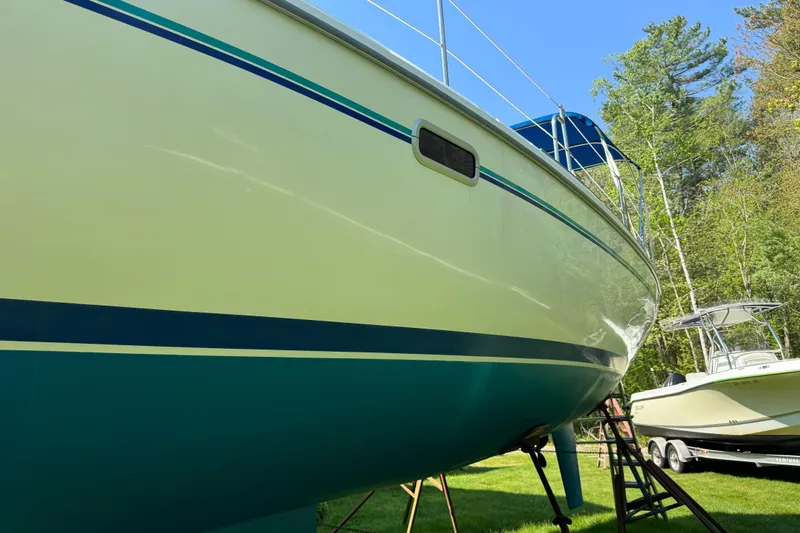 Slide: The Image of 1996 Catalina 36 MkII sailboat on land, surrounded by trees and another boat. - 8