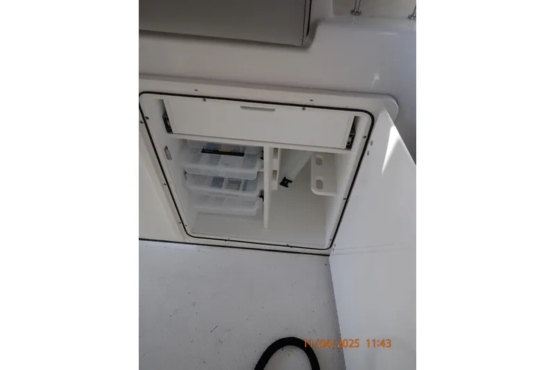 Slide: The Image of Storage compartment on a 2023 Pursuit S 328 Sport boat, featuring organized shelves. - 7