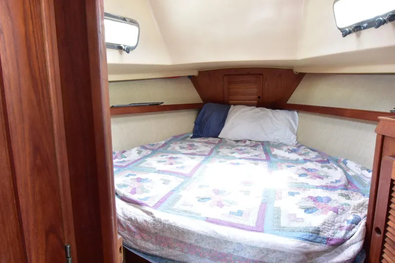 Slide: The Image of Cozy cabin interior of 1994 Island Packet 32 sailboat with quilted bedding. - 11