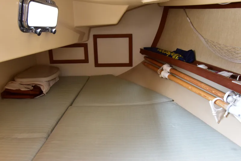 Slide: The Image of Cozy cabin interior of 1994 Island Packet 32 sailboat with cushions and storage. - 14